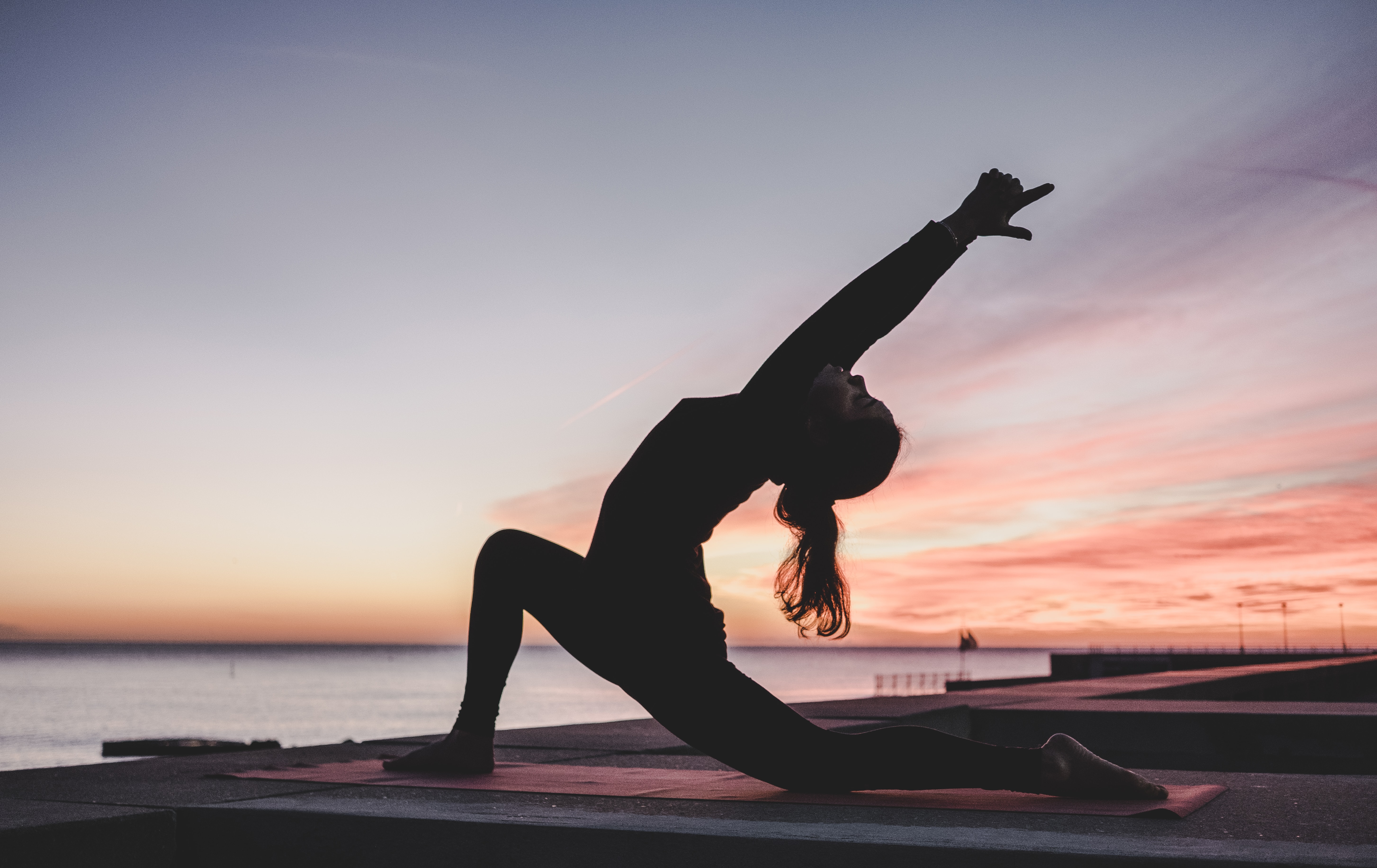 In March of last year, the world as we knew it changed. And now, many of us are feeling the post-pandemic social anxiety. Woman doing yoga as coping.